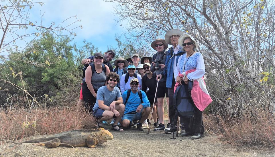 Group of travelers next to a land iguana
