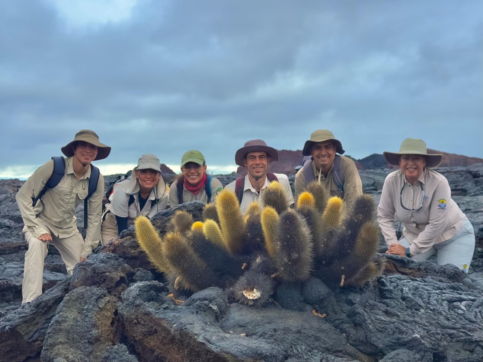 Uniformed guides smiling next to a lava cactus