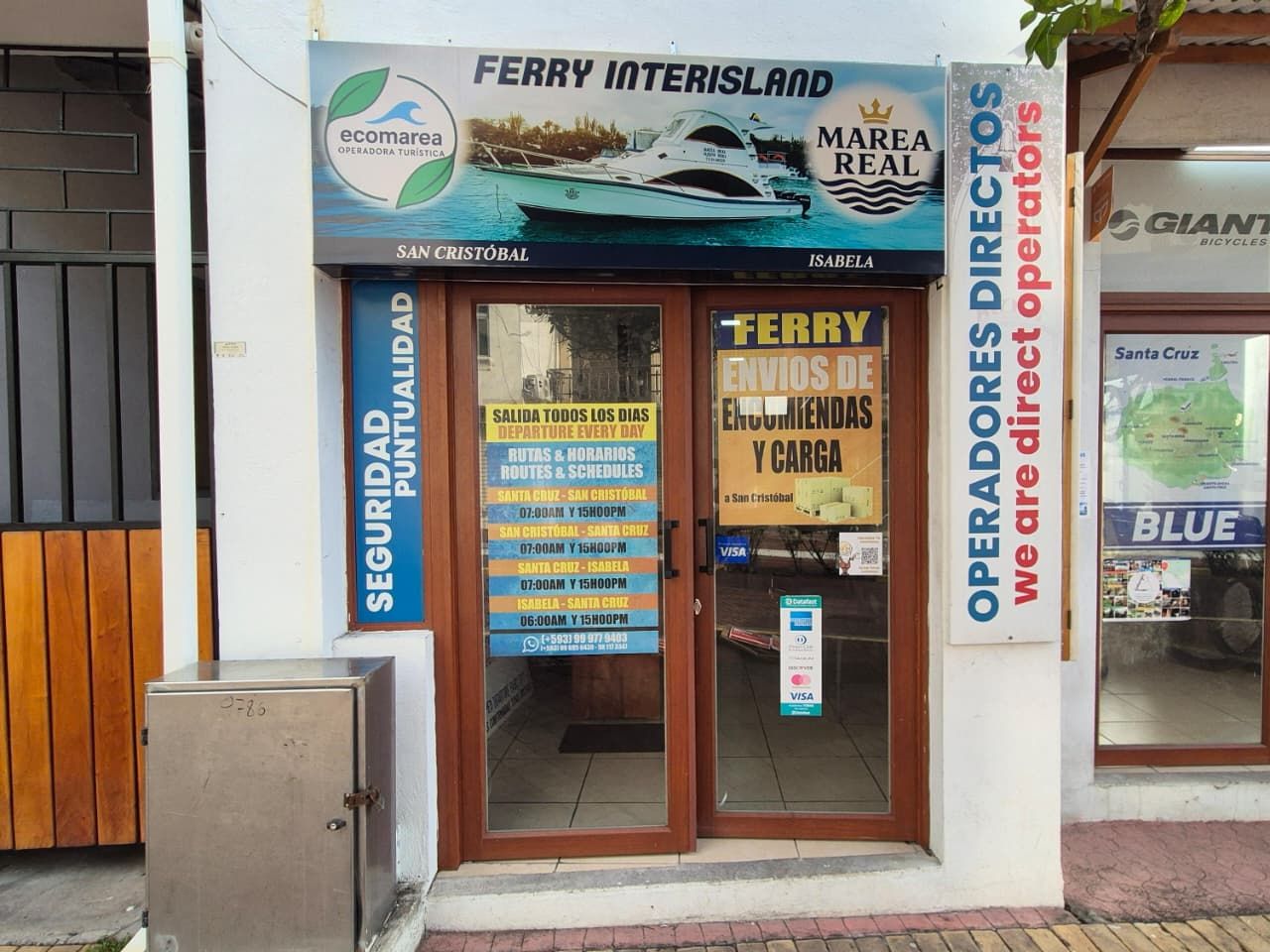 Front of the Ecomarea office in Puerto Ayora, with the Ferry Interisland sign and the Marea Real boat