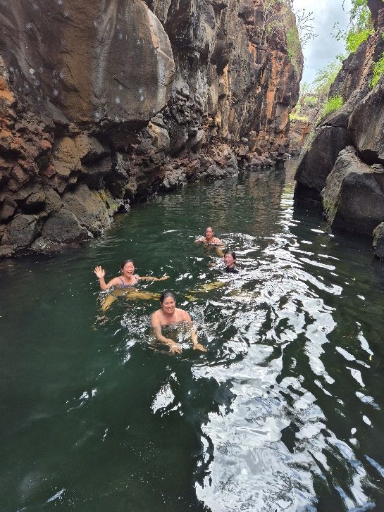 Travelers swimming at Las Grietas, between walls of volcanic rock